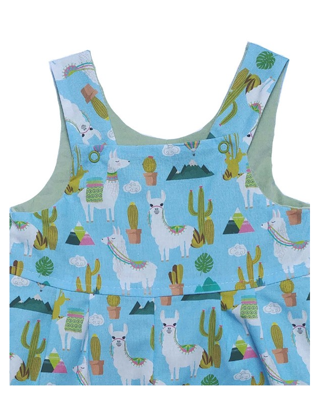 Close-up of Llama Reversible Dungarees bib by Seesaw, sky blue llama and cactus print with snap button detail