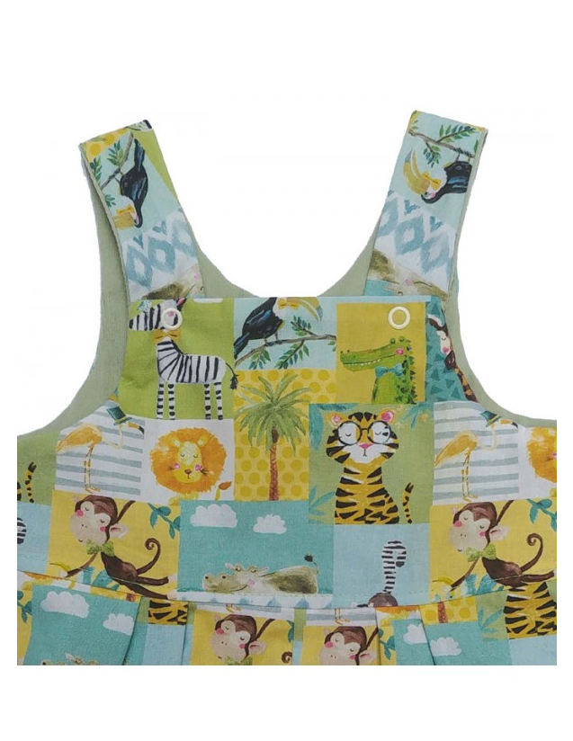 Close-up of Jolly Jungle Reversible Dungarees bib by Seesaw, patchwork jungle print with illustrated animals on mint and yellow background