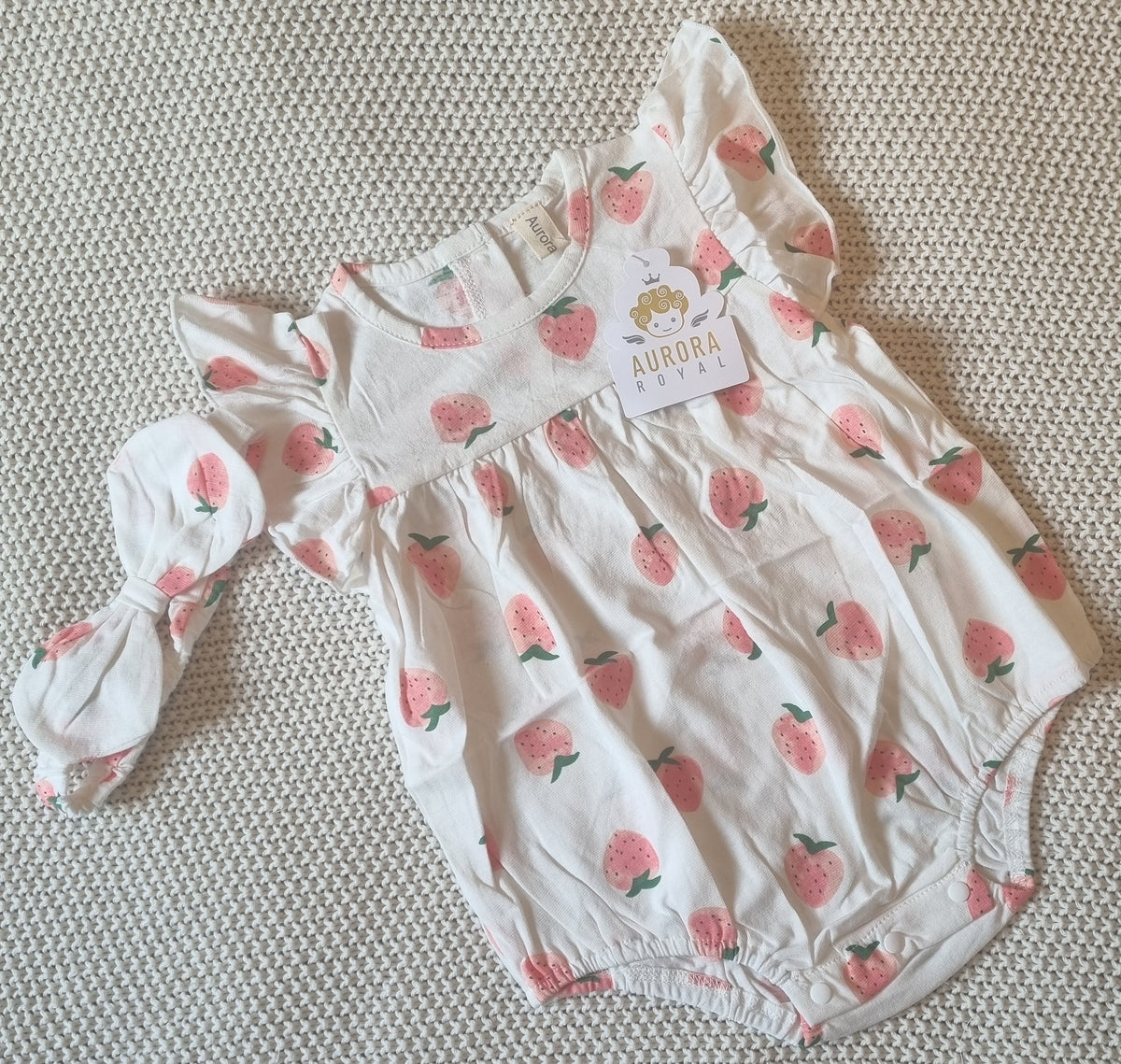 White and cream baby romper with pink strawberry print and matching headband